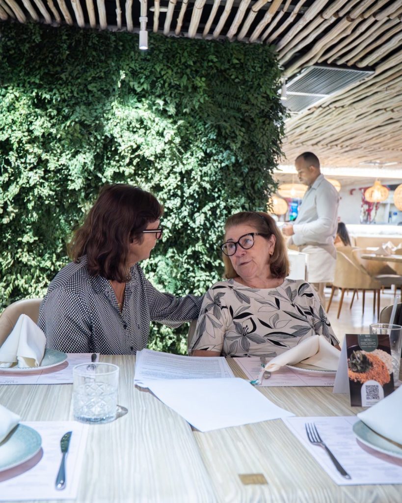 mulheres mais sentadas na mesa conversando